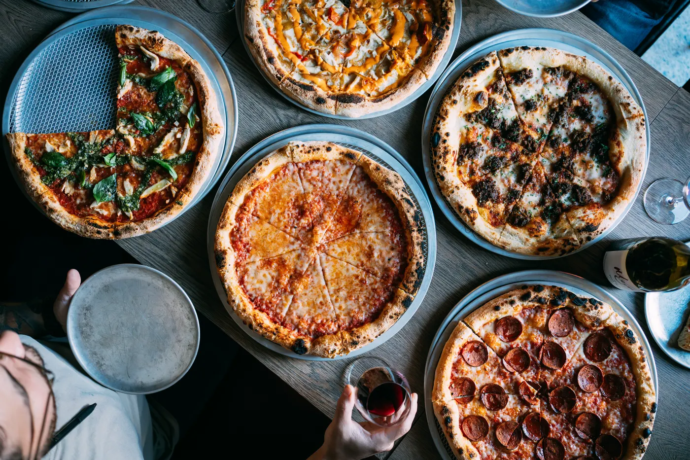 Overhead spread of Brooklyn-style pizzas on the table